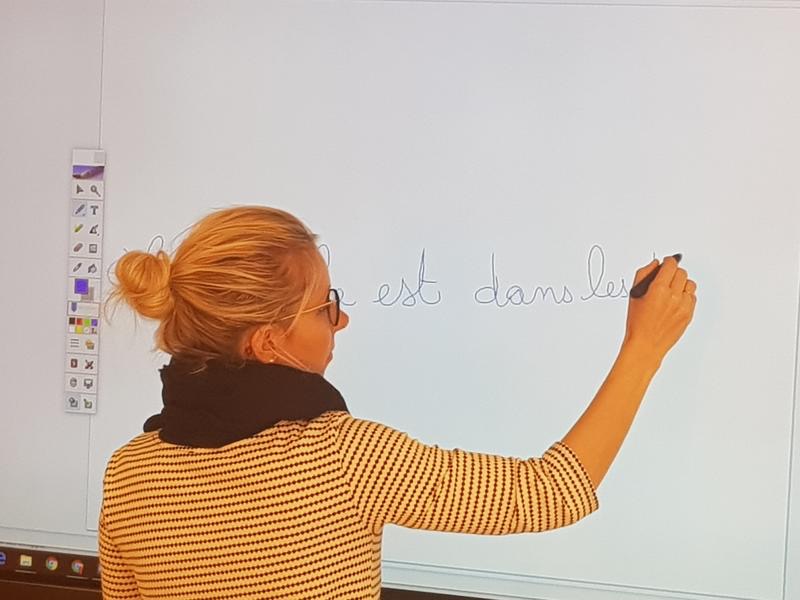Une enseignante de Français à l’école de Notre Dame des missions utilise le logiciel interactif d’annotation pour écrire
